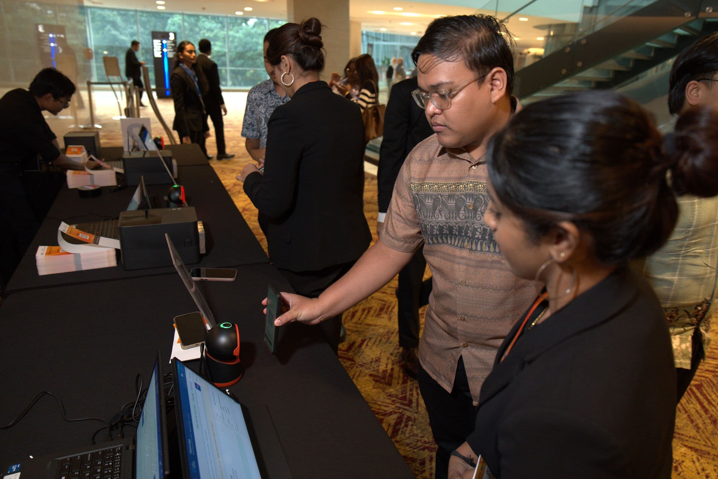 Attendees checking in with tablets at the registration desk, Youth Economic Forum 2026