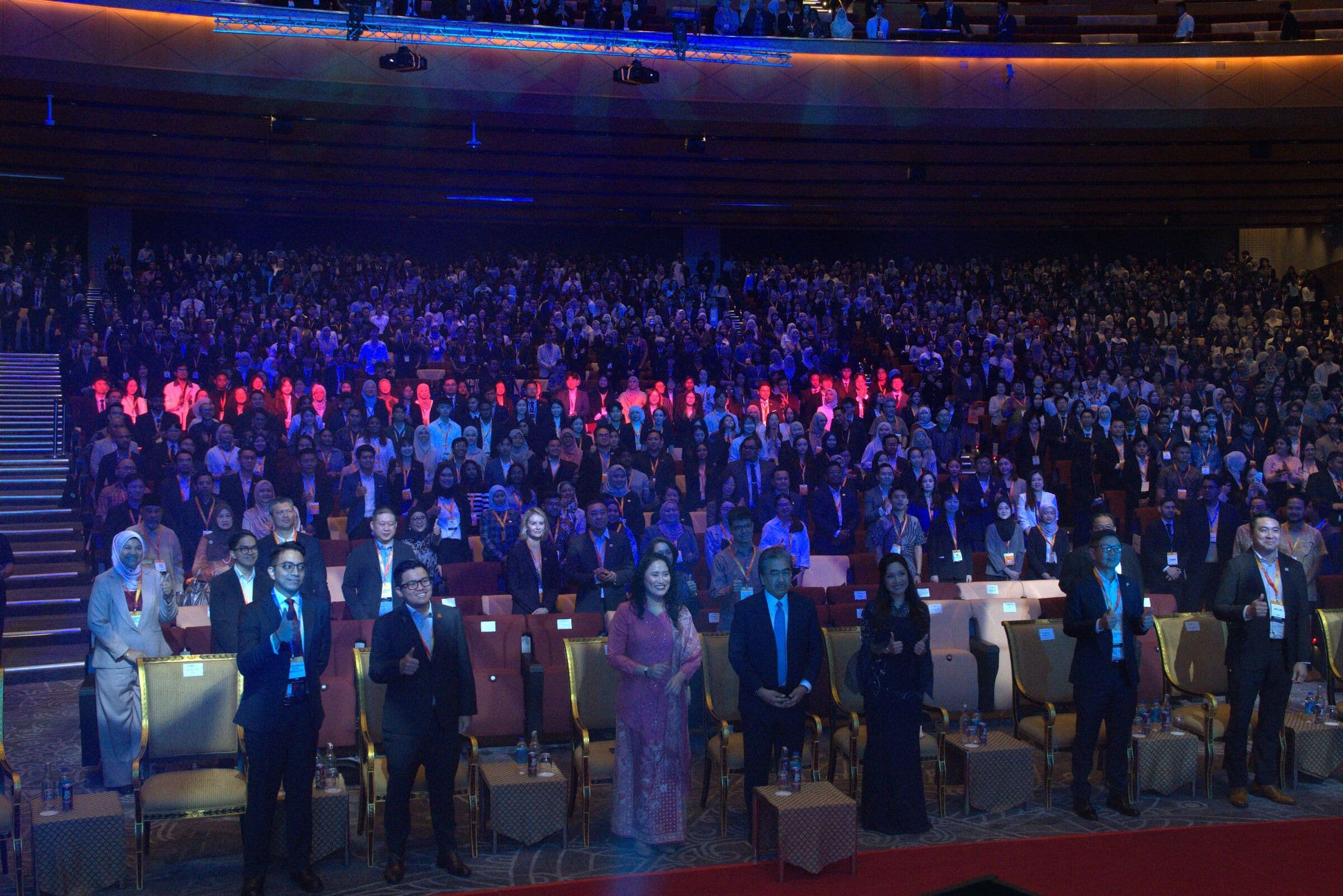 Delegates standing in a full hall at the start of the Youth Economic Forum 2026