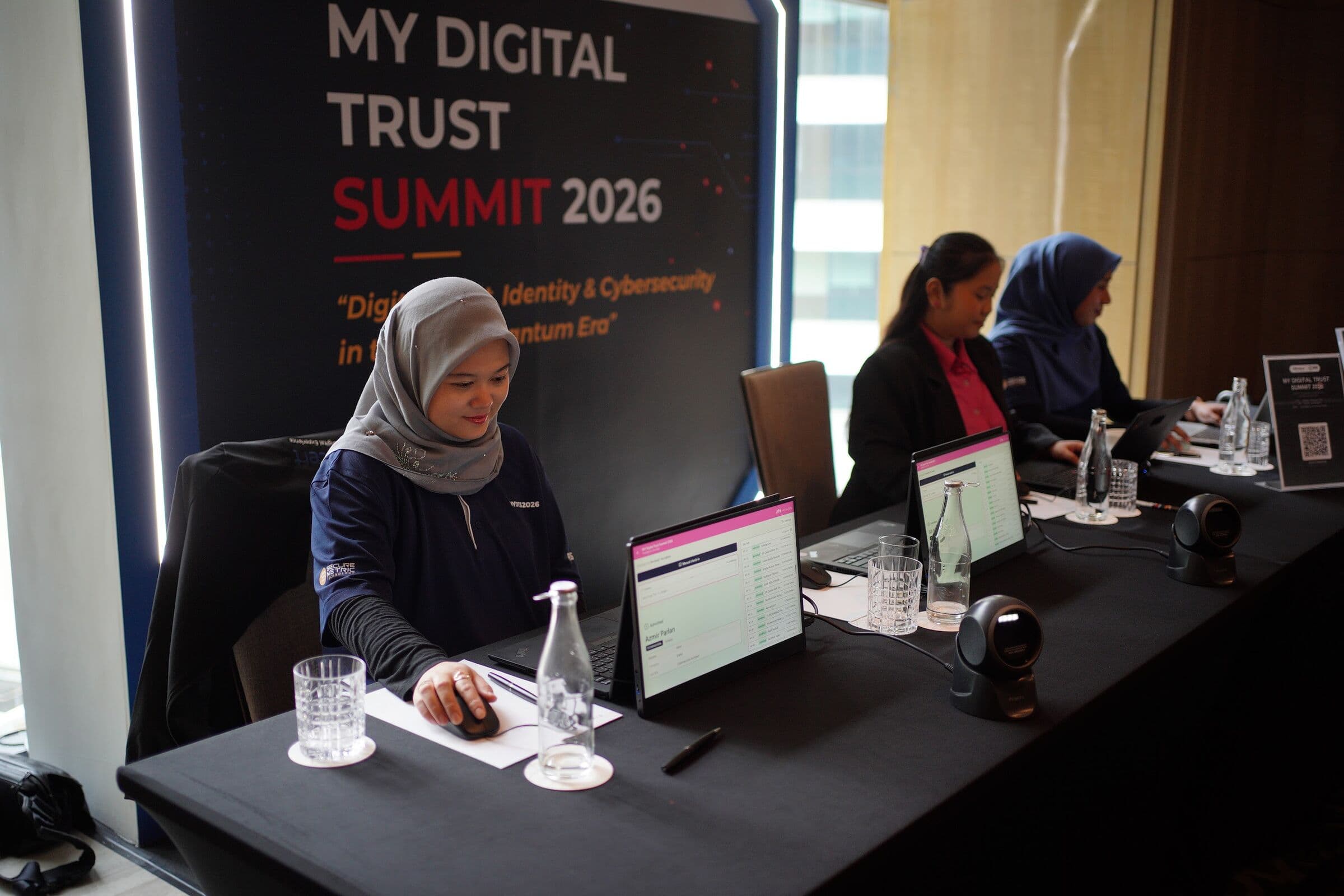 Registration desk with tablets and scanners in front of the MY Digital Trust Summit 2026 backdrop